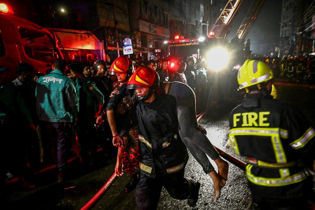 一名消防员擡著在火灾中受伤的人，送往救治。（图取自法新社）
