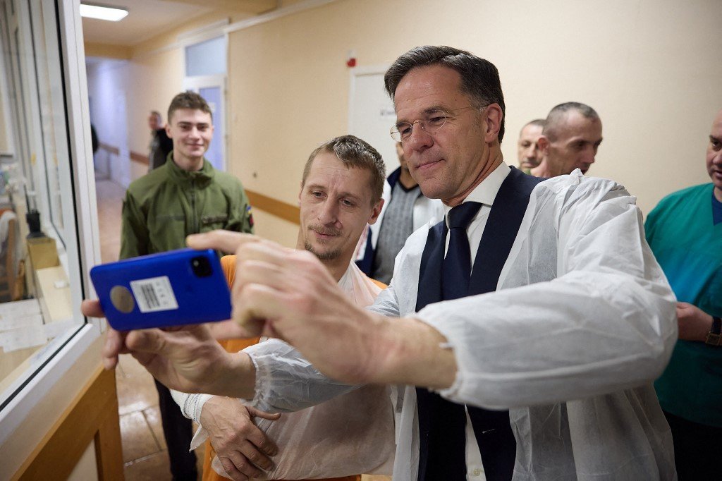 荷兰首相吕特（右）在哈尔科夫医疗临床中心与一名受伤接受治疗的乌克兰军人合影。（图取自乌克兰总统府新闻处/法新社）