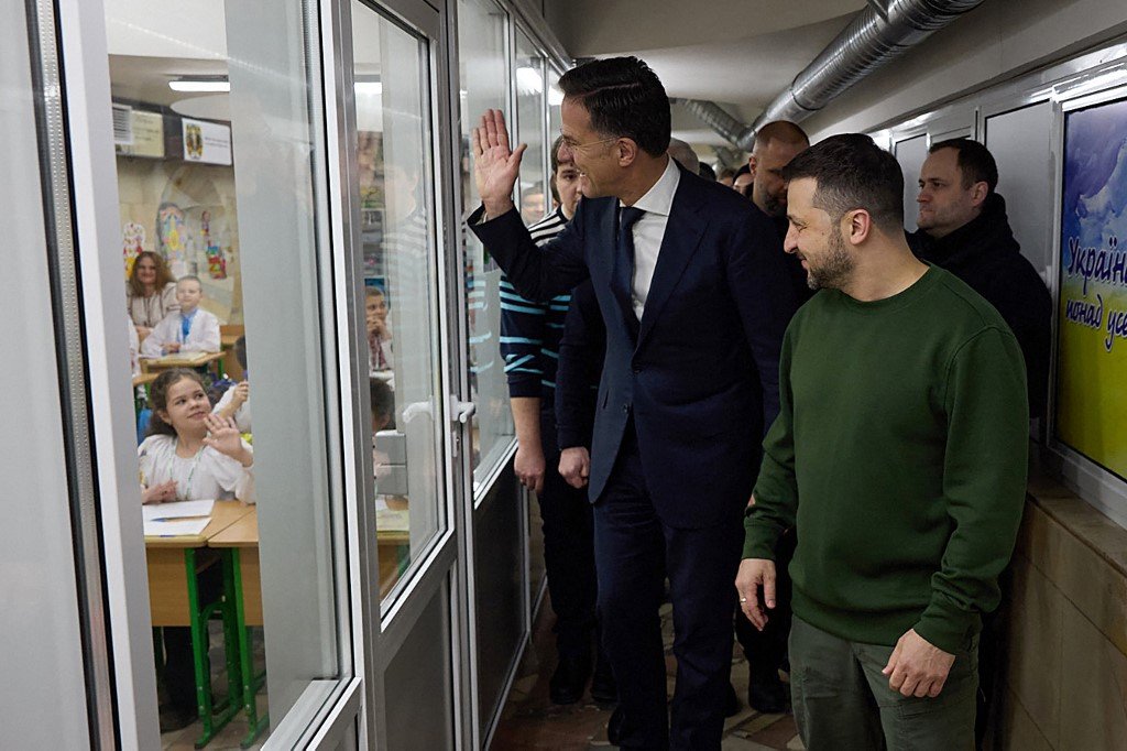 泽连斯基（右）与吕特在参观哈尔科夫地铁通道内的一所特殊学校，吕特向学生们挥手致意。（图取自乌克兰总统府新闻处/法新社）