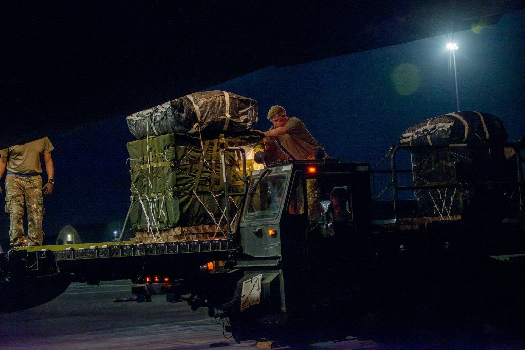 美国军人上周五将一托盘人道主义援助物资装载到一架货机上，准备在加沙上空空投。（图取自法新社/美国国防部）