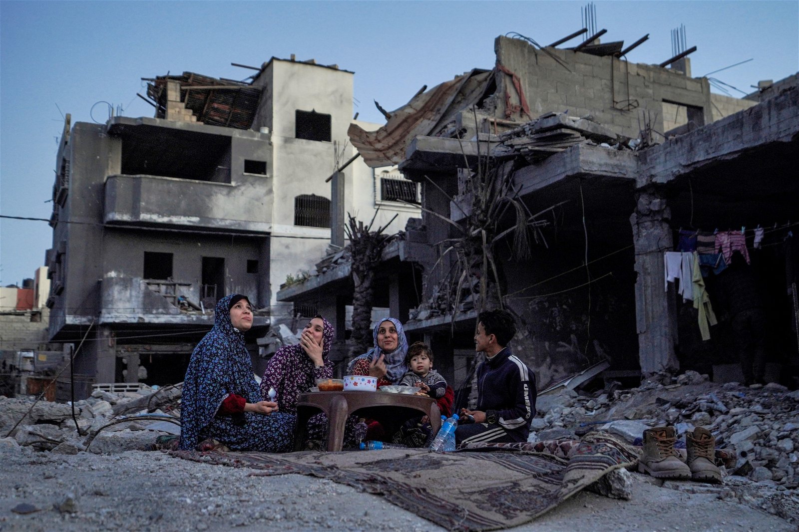 加沙地带中部城市代尔拜拉赫的阿尔纳吉一家，当地时间周一在自家房屋的废墟中吃开斋晚餐。（图取自法新社）