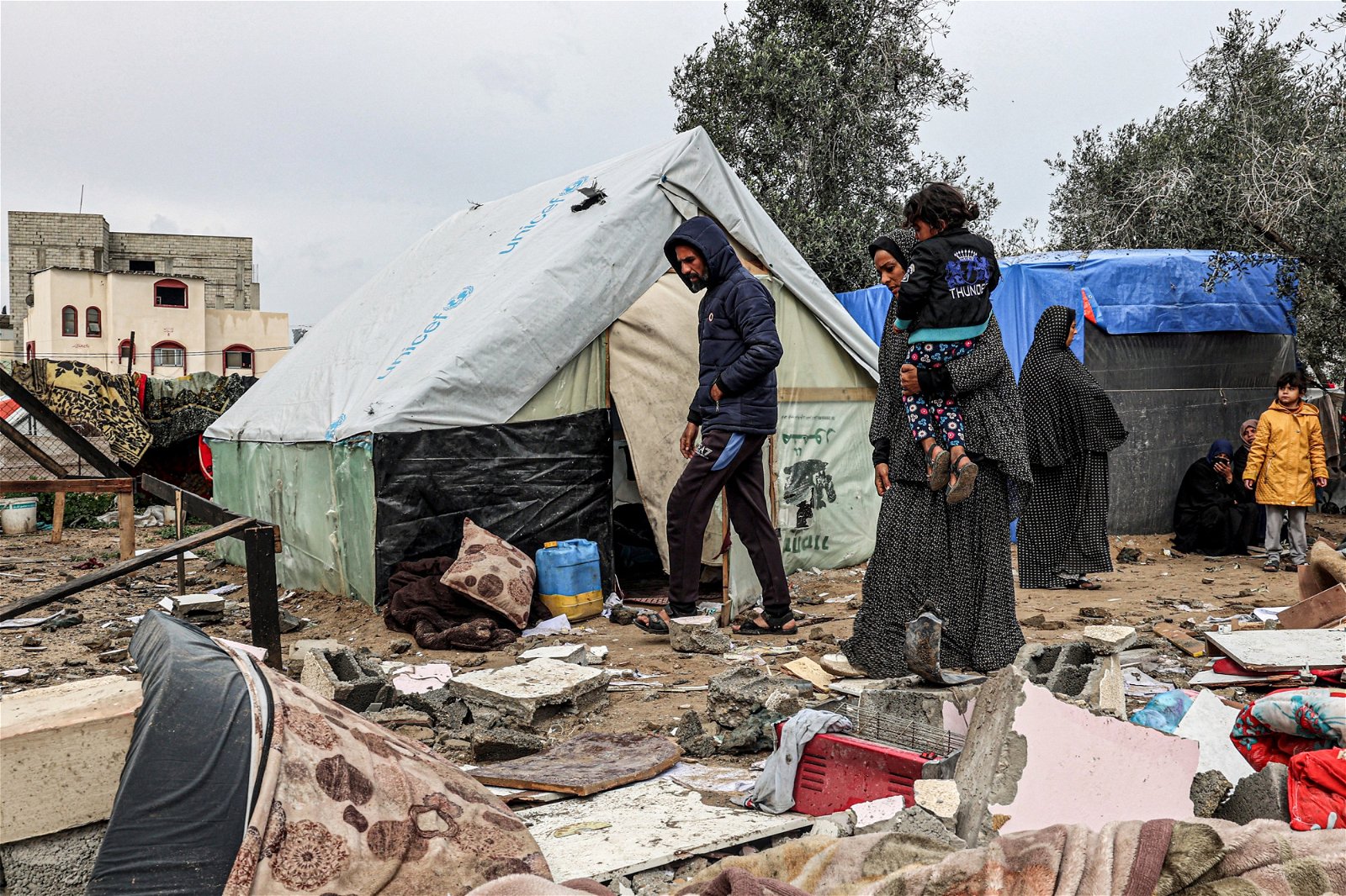 以色列周一连夜轰炸加沙地带南部城市拉法的难民营，流离失所的巴勒斯坦人周二回到难民营，查看帐篷的损坏情况。（图取自法新社）