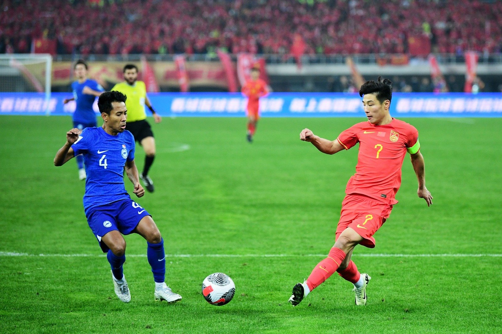 中国队球员武磊（右）在与新加坡队的比赛中射门。 （图取自中新社）