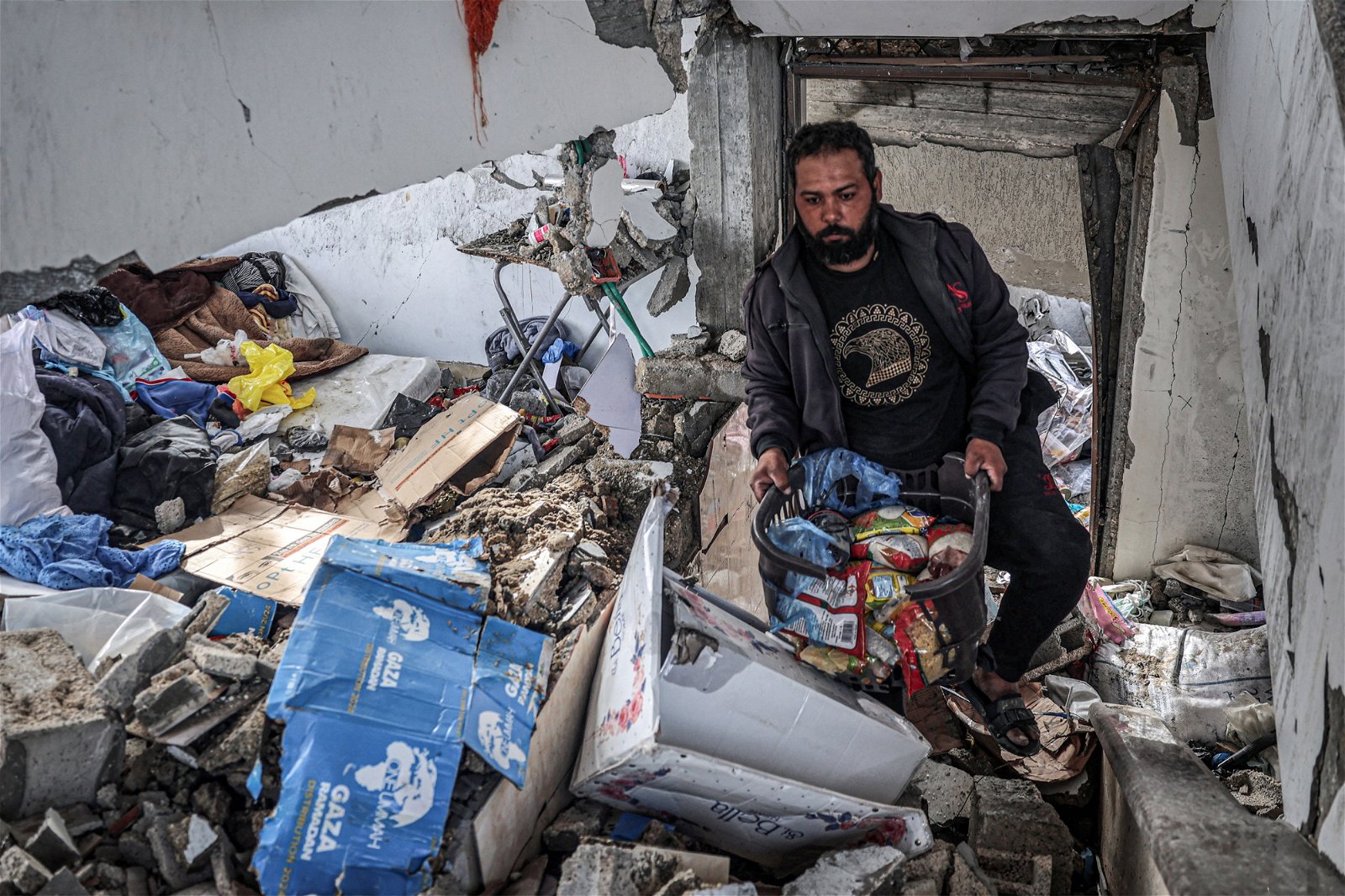 加沙地带正经历战乱，当地的巴勒斯坦人在遭受以色列轰炸的南部拉法的废墟中收集食物。（图取自法新社）
