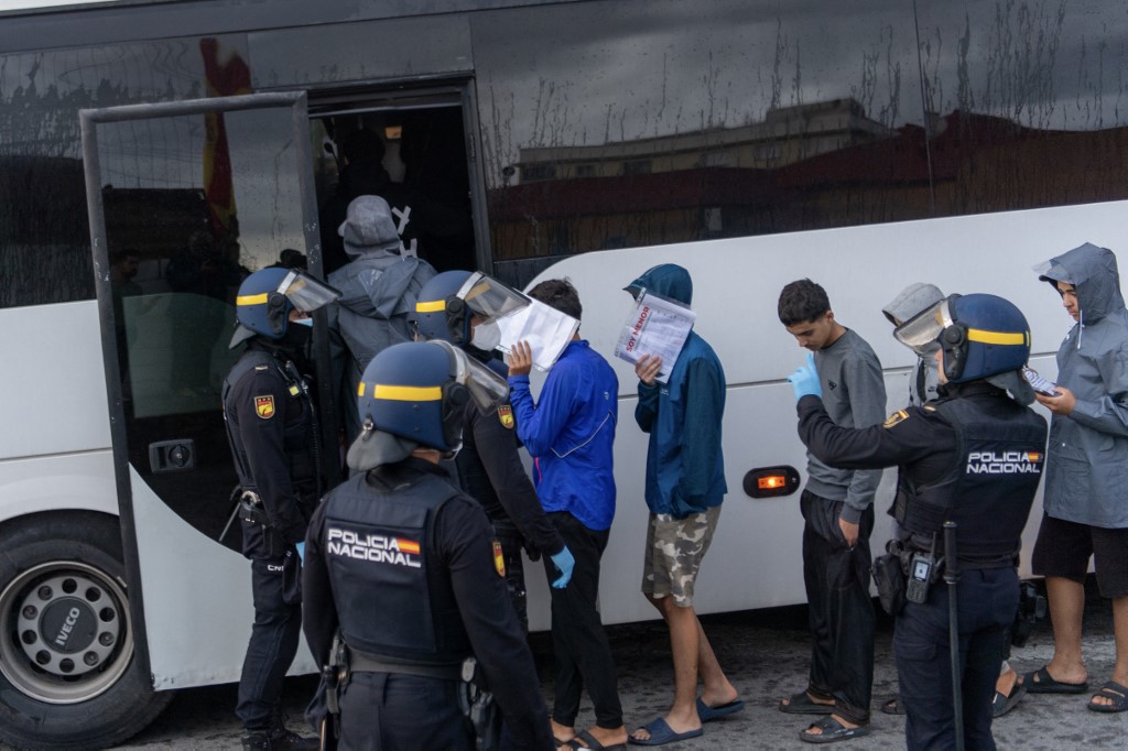 10月18日，西班牙警方在西班牙北非飞地休达郊区的塔拉哈尔仓库外围捕移民。（图取自法新社）