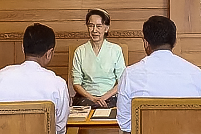 缅甸内政部本周一发布的照片​​显示，被拘留的前国务资政昂山淑姬（中）在首都内比都与内政部官员会面，并收到了英国国王查尔斯三世寄来的包裹。（缅甸内政部/法新社档案照）