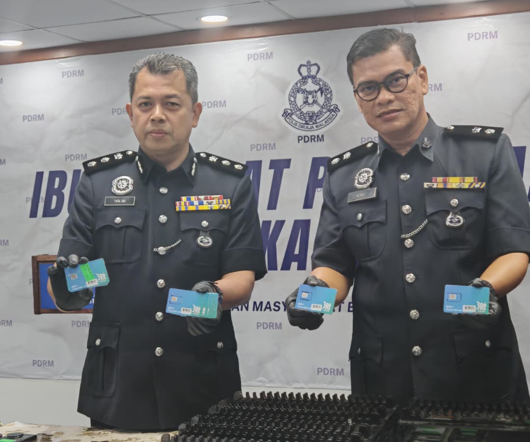 哈林（左）与阿兹鲁一同出示警方所充公的SIM卡。