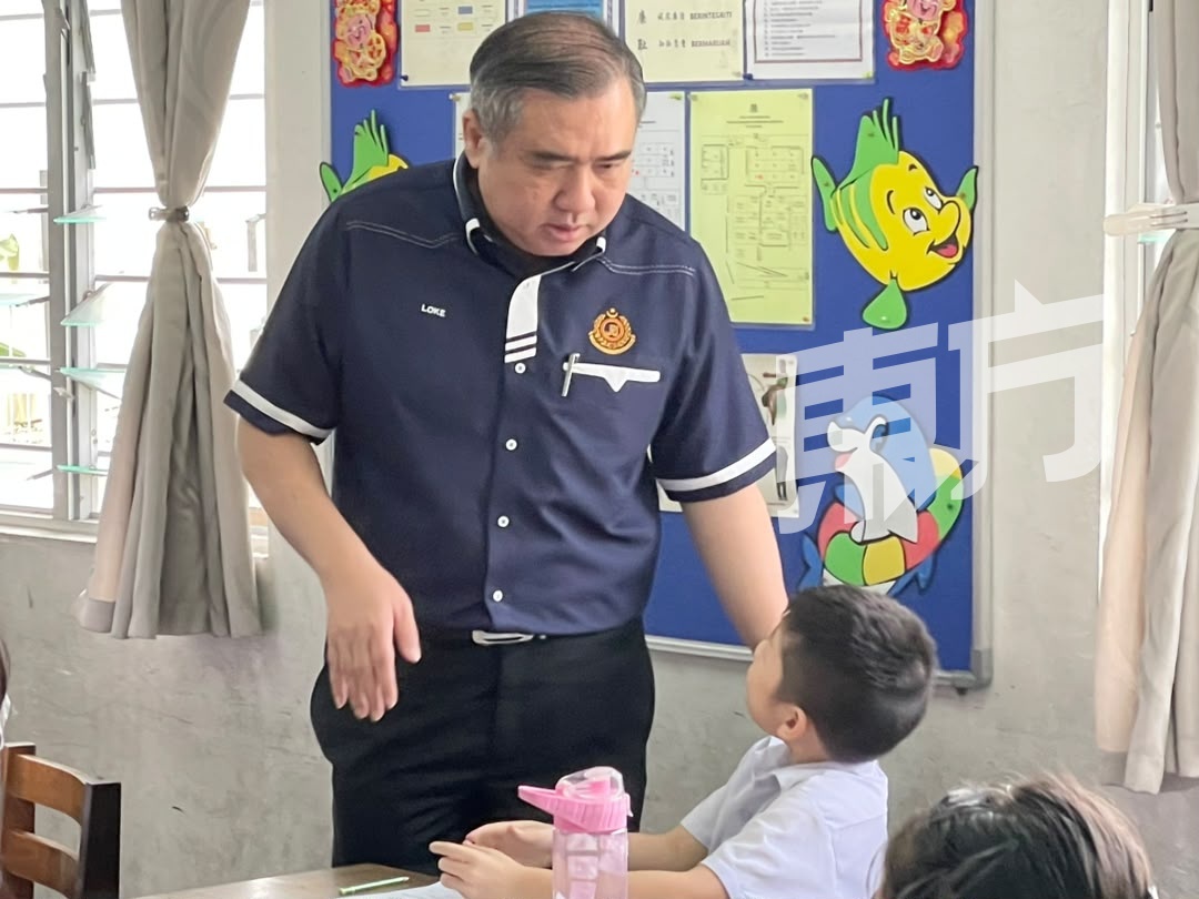 陆兆福（左）到课室里与小学生交流。