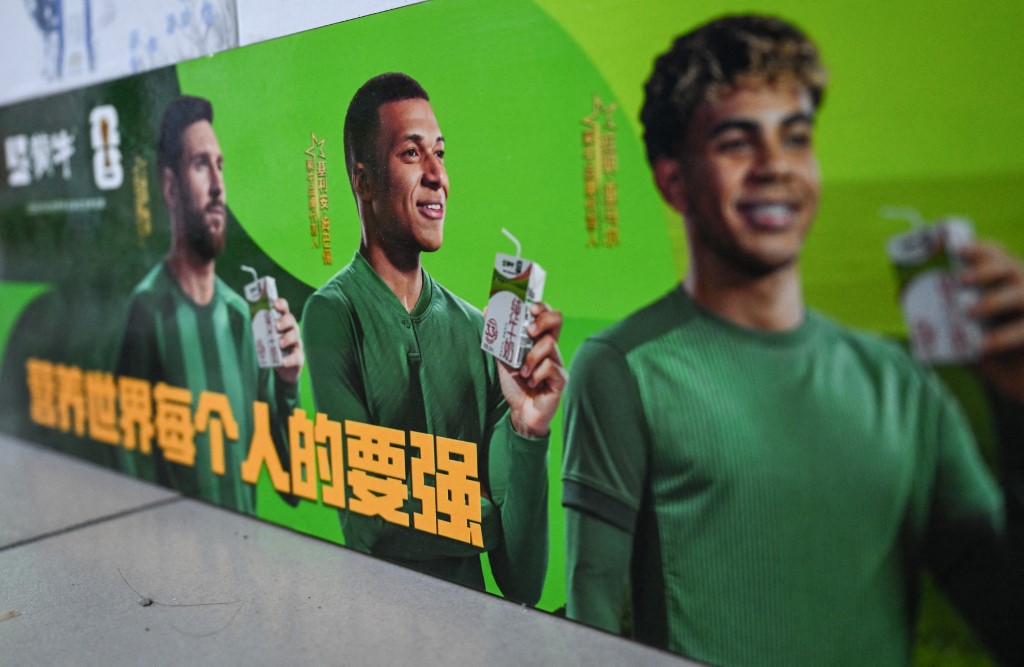 周三在中国首都北京一家超市可见，中国乳制品品牌蒙牛的促销活动，仍然可见印有姆巴佩（中）肖像的宣传板。（图取自法新社）