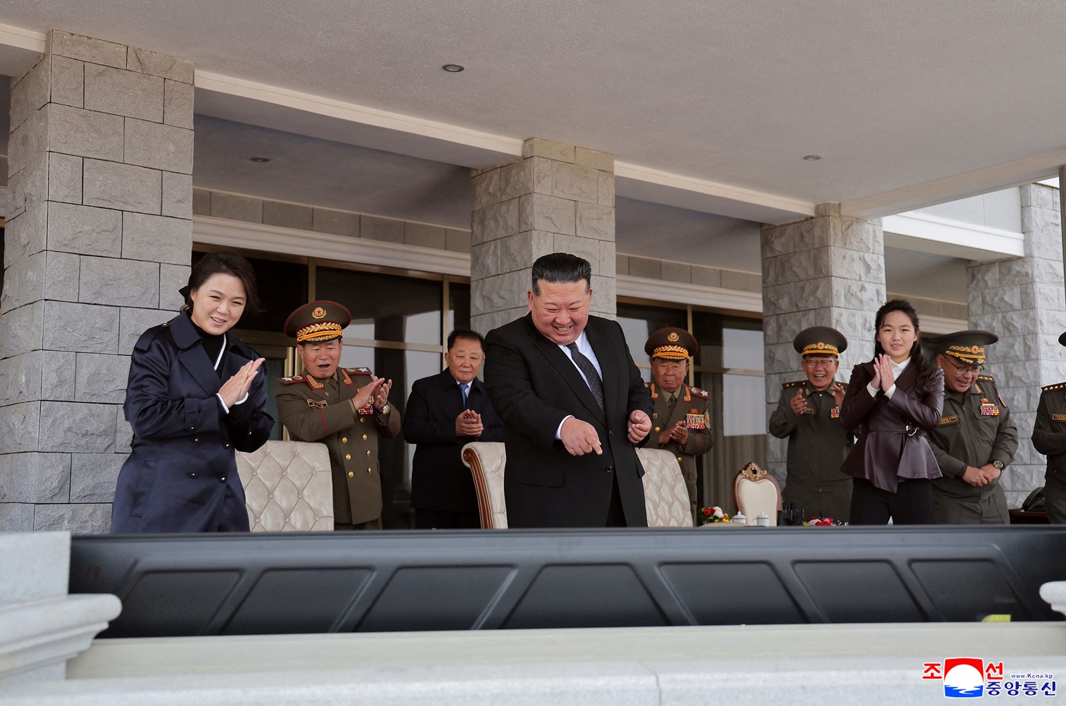 朝鲜最高领导人金正恩周四透过荧幕，观看“无人航空技术发展-2026”展览的无人机和武器系统演示。妻女陪同在侧的他，满脸笑容地指著荧幕，似乎对演示非常满意。（图取自朝中社）