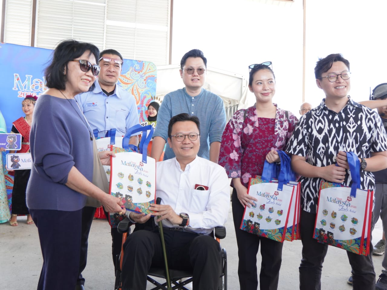 杨顺兴亲自分发迎宾小礼袋给旅客。