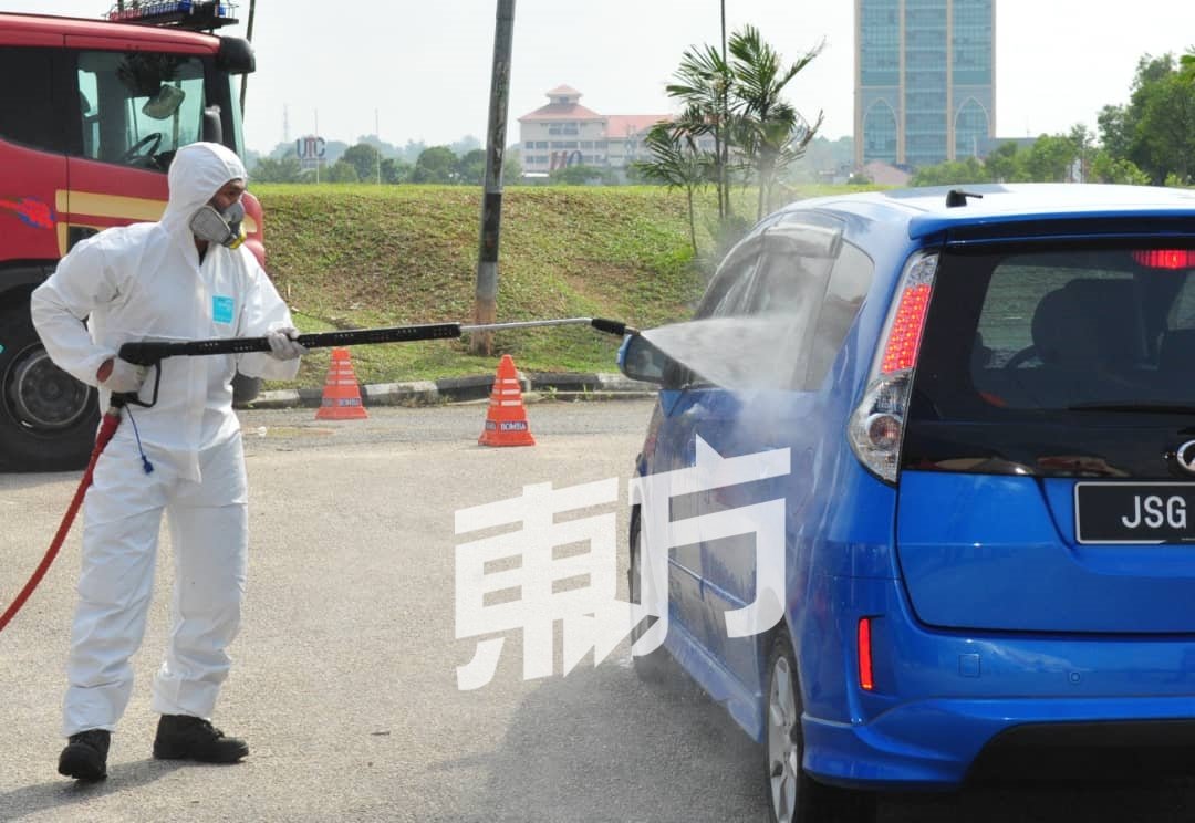 工作人员以消毒水清洗前来求诊民众的车辆。（摄影：杨金森）