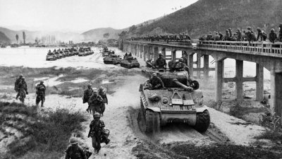 1950年10月17日，朝鲜战争期间，美国陆军第2步兵师的一列坦克绕过黄江上一座受损的桥梁。（图取自法新社）