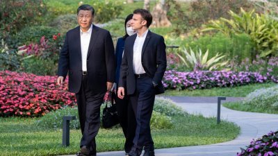 中国国家主席习近平（左）上周五与国事访问中国的法国总统马克龙参观广东省省长官邸花园，这里曾是习近平父亲习仲勋的居住过的地方。（图取自法新社）