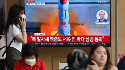 在首尔火车站的电视屏幕，播放带有朝鲜火箭发射档案镜头的新闻广播。（图取自法新社）