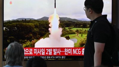 在韩国首尔的一火车站，民众看著电视播放有关朝鲜发射导弹的新闻报导。（图取自法新社）