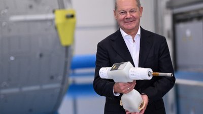 德国总理肖尔茨上周五在参观位于德国西部科隆的欧洲航天局（ESA）期间，拿著一把在中性浮力设施的潜水训练中使用的无线电动螺丝刀。（图取自法新社）