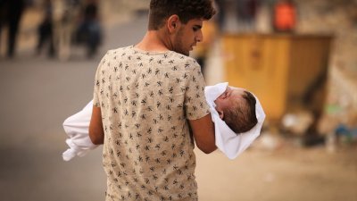 扎纳蒂家族的一名小孩在以色列的空袭中，与其他家庭成员一起遇害。据信是亲属的男子周一抱著小孩的尸体，将他抬上一辆等待的车辆，准备在汗尤尼斯下葬。（图取自法新社）