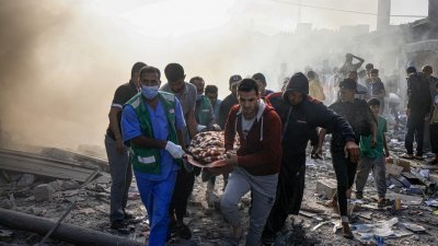 以军持续空袭加沙地带，周二在南部汗尤尼斯的袭击后，巴勒斯坦人抬著一名轰炸的受害者。（图取自法新社）