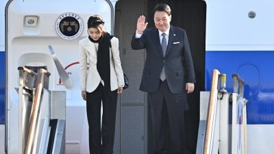在位于京畿道城南市的首尔机场，韩国总统尹锡悦（右）和夫人金建希周一乘总统专机启程赴英国，开启为期7天的英国、法国访问之旅。（图取自法新社）