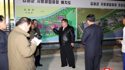 朝鲜官媒周四发布照片，显示最高领导人金正恩（中）前一天视察江原道金化郡的一家工业工厂。（图取自朝中社/法新社）