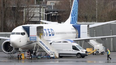 1月25日在华盛顿伦顿波音工厂附近的伦顿市政机场，一个人走过联合航空公司一架波音737 MAX 8 飞机。（图取自法新社档案照）