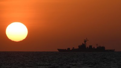 2月15日拍摄的照片显示日出时，一艘中国海军舰艇位于中国控制的黄岩岛附近。（图取自法新社）