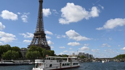 巴黎奥运会安保官员透露，开幕式上总共将有180艘船沿塞纳河入场，其中94艘船将搭载运动员。图为一艘佩尼谢船去年7月17日，在塞纳河上驶过埃菲尔铁塔。（图取自法新社档案照）