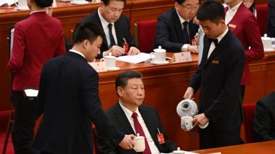 中国十四届全国人大二次会议周二早在北京人民大会堂开幕，中国国家主席习近平出席入座后，现场工作人员为他添茶。（图取自法新社）

