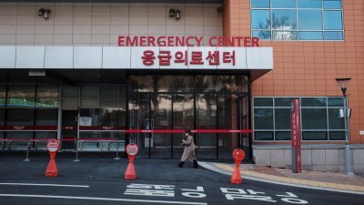 一名妇女上周五途径韩国首尔一家医院。（图取自法新社）
