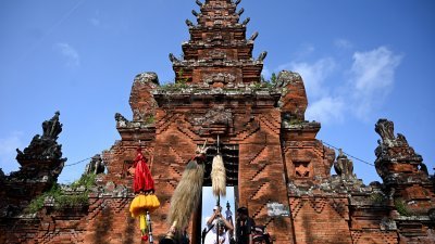 3月17日，巴厘岛人民在度假胜地登巴萨凯西曼的一座寺庙参加传统仪式。（图取自法新社）