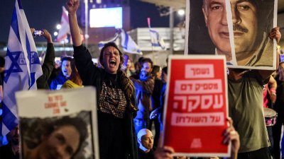 以色列左翼人士上周六（16日）晚聚集在特拉维夫举行反政府示威，一名抗议者高喊口号。（图取自法新社）
