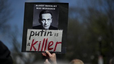当地时间周日在俄罗斯驻美国华盛顿大使馆外，有反普京的民众高举已故俄罗斯反对派领袖纳瓦尔尼的照片，表示纳瓦尔尼是遭到谋杀，而杀人凶手就是普京。（图取自法新社）