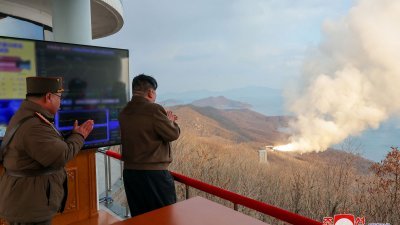 朝鲜官媒周三发布照片，称该国前一天成功进行了新型中远端高超音速导弹多级固体燃料发动机地面点火试验，最高领导人金正恩（右）到场指导。（图取自朝中社/法新社）