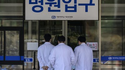 数名医护人员周四步入韩国首尔一家医院。（图取自法新社）