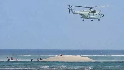 菲律宾渔业和水产资源局3月25日拍摄并发布的影片截图显示，一架中国直升机在菲律宾科学家检查南沙群岛中业岛附近的一个珊瑚礁时盘旋。（图取自菲律宾海岸警卫队/法新社）