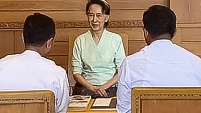 缅甸内政部周一发布的照片​​显示，被拘留的前国务资政昂山淑姬（中）在内比都会见了内政部官员。（图取自缅甸内政部/法新社）