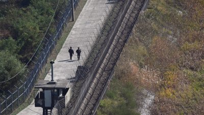 周二从韩国边境城市坡州的一处韩国瞭望台拍摄到，韩国士兵在分隔韩朝的非军事区（DMZ）南侧的军事围栏沿线巡逻。（图取自法新社）