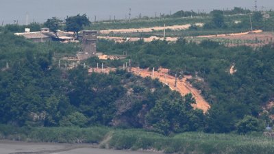 7月1日，从韩国金浦市爱妓峰和平生态公园的观景台上拍摄的照片显示，位于朝鲜边境开丰区域的非军事区（DMZ）朝鲜一侧，可以看到朝鲜的哨所和军事围栏。（图取自法新社档案照）