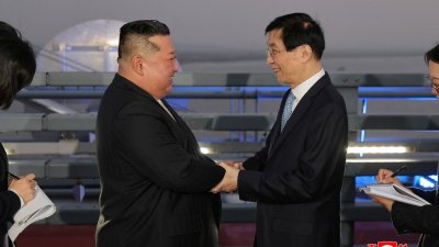 据朝鲜官媒周日报导，最高领导人金正恩24日访问辽宁省丹东。图为金正恩（左）与前来迎接的中共中央政治局常委、全国政协主席王沪宁握手致意。 （图取自朝中社／法新社）