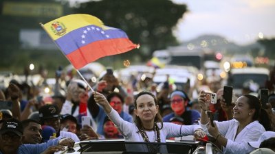 当地时间周日，委内瑞拉反对派领袖、诺贝尔和平奖得主马查多抵达加拉加斯后向支持者致意。（图取自法新社）