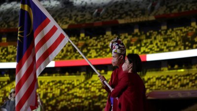 国际奥委会致力将2020东京奥运会打造成首届性别平等奥运，并在开幕仪式上安排一男一女作为各个代表团旗手。图为李梓嘉和吴柳莹担任马来西亚棋手，率领大马代表团入场。（图取自路透社）