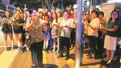 叶舒惠（左3）于周六晚上率百人在妇女撞后逃案发现场举办一场烛光会，以提醒道路使用者遵守规则，同时也呼吁行人不因这次事件而对步行产生恐惧。