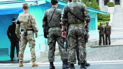 美国副总统彭斯（不在镜头内）访问韩国时，前往板门店休战区视察，朝鲜士兵举相机拍摄。