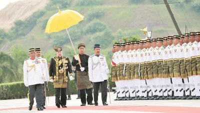 在登基仪式开始前，莫哈末五世（中）在国家王宫检阅马来皇家兵团仪仗队。