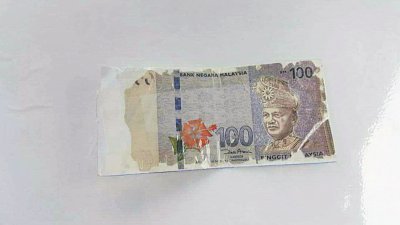 一名妇女不满从银行领取5张破损的100令吉纸钞，其中一张严重脱色。