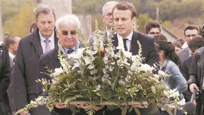 法国总统候选人马克龙（右）周五到访二战纳粹大屠杀遗址—奥拉杜尔村，并于幸存者联手献上花圈致哀。
