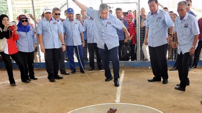 副首相阿末扎希（中）在实比丹举行的国际陀螺及大斗磨嘉年华会上，亲身上阵玩起传统陀螺。