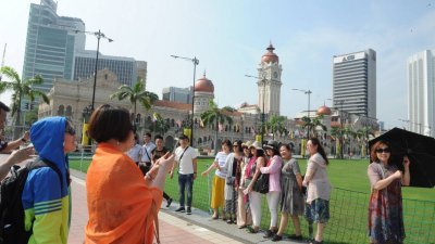 中国的“五一黄金周”预计将吸引逾10万人到马来西亚旅游，从本月27日开始，中国旅客已陆续抵达大马。图为中国游客在独立广场前留影。 （摄影：徐慧美）-