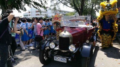 90“高龄”的VINTAGE古董车在舞狮团及师生夹道欢送下，载著骆贵清夫妇离开北海钟灵中学。